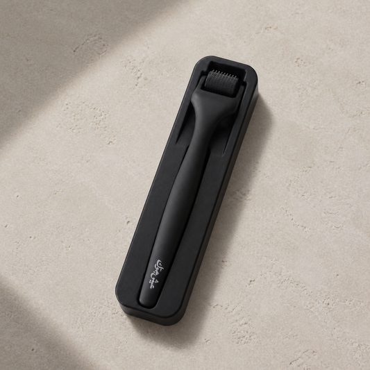 Diggn'It Derma Roller in its protective storage case on a warm stone surface
