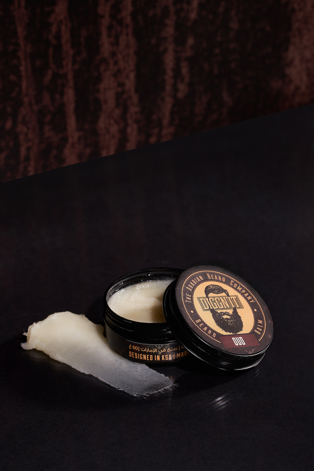 Open Oud Arabian Beard Balm tin on a dark styled backdrop