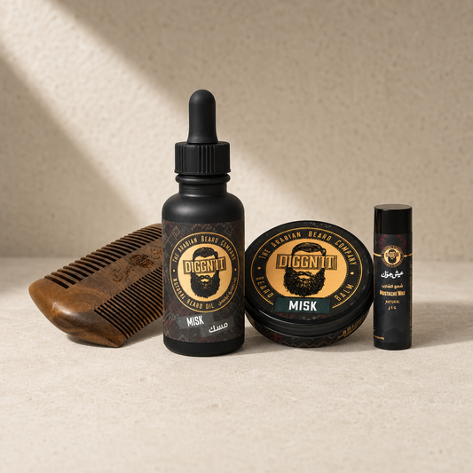 Beard Care Bundle with Misk Arabian Beard Oil, Misk Arabian Beard Balm, Natural Mustache Wax, and Sandalwood Beard Comb on warm ivory stone