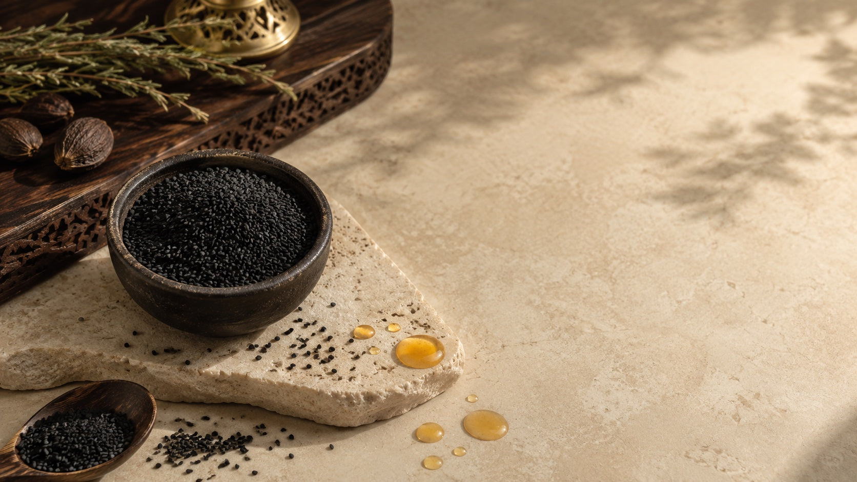 Black seed in a bowl with oil drops on a stone surface