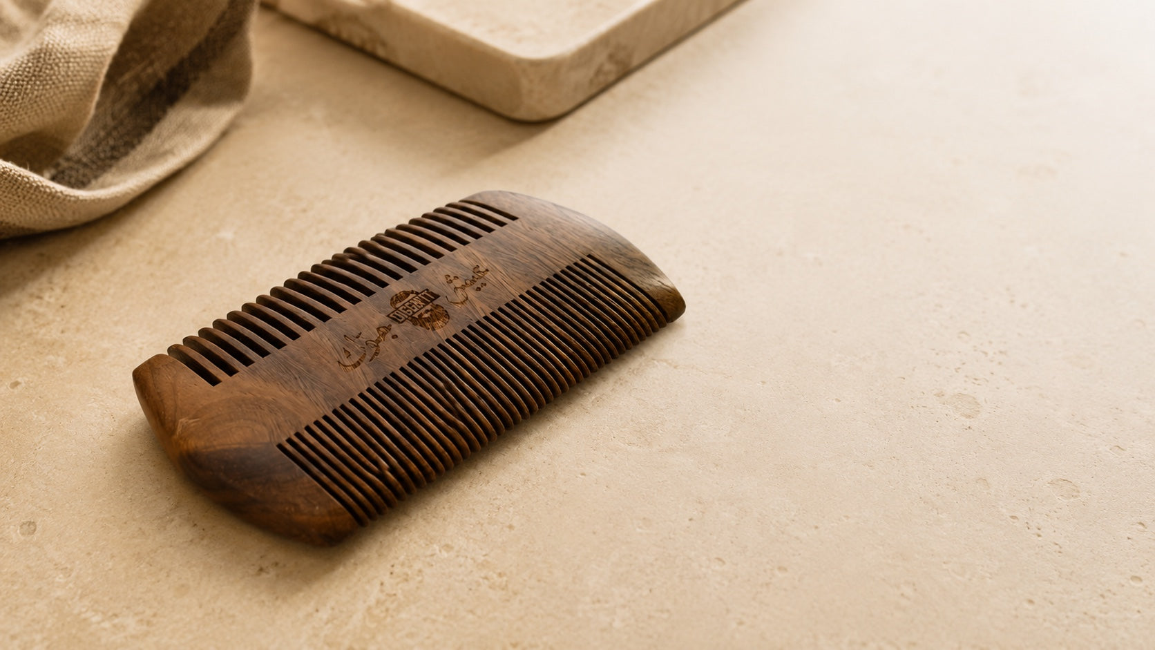 DiggnIt sandalwood beard comb on a warm stone surface